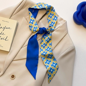 Élégant foulard en soie bleu Klein à motifs géométriques sur un blazer beige chic