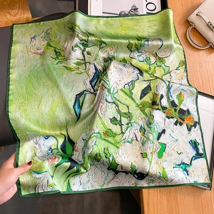 Carré en soie avec imprimé floral style Van Gogh vert posé sur une table en bois