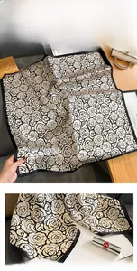Detailed view of camellia silk scarf with premium black and white rose floral pattern