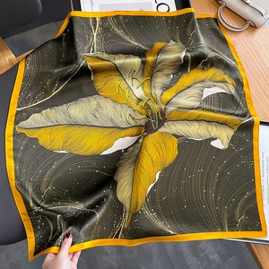 Olive green silk square scarf with golden leaf prints shown in a lifestyle setting