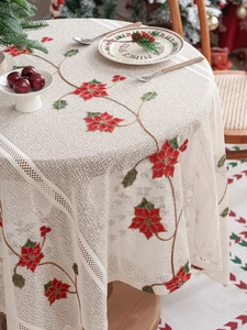 Dettaglio della tovaglia in pizzo bianco con ricamo di stella di Natale rossa per decoro