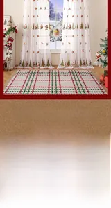 Detail view of sheer Christmas curtains with Santa and tree prints in a cozy room