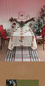 Detailed embroidery of Santa Claus and reindeer on a festive white Christmas tablecloth