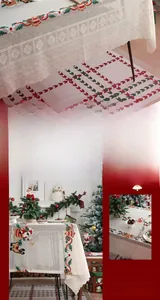 Detail of Christmas lace tablecloth with reindeer and Santa embroidery on wavy edge