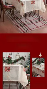 Close-up of festive lace tablecloth with red bow, bell and floral embroidery detail