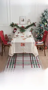 Detail of white Christmas lace tablecloth with red bow embroidery and Santa chair covers