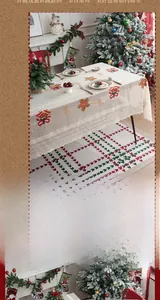 Close-up of Christmas white lace tablecloth with bell embroidery and red bows