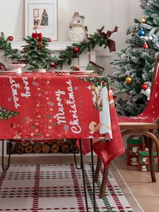 Detail of red Merry Christmas tablecloth with festive tree and snowflake print patterns