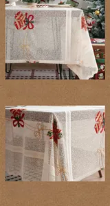 Detail of white lace Christmas tablecloth with red bell and gold ribbon embroidery