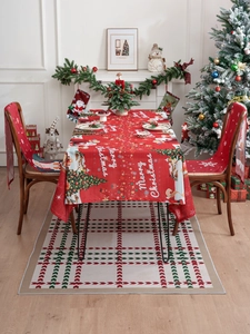 Detail of red Merry Christmas tablecloth and matching chair covers in festive home setting