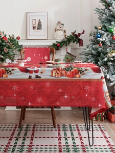 Detail of red Christmas tablecloth and chair covers with festive Santa and snowflake prints