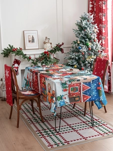 Detail of Christmas tablecloth with hand-drawn Santa and snow cabin illustrations