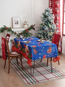 Detail of blue Christmas tablecloth and red chair covers with Santa and reindeer motifs