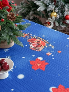 Detail of blue striped Christmas tablecloth with Santa, reindeer and poinsettia prints