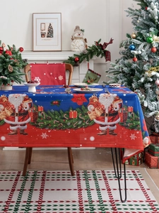 Detail of Christmas tablecloth with Santa and pine needles in festive home setting