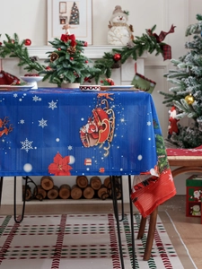 Detailed close-up of festive Christmas tablecloth with Santa and reindeer pattern in blue