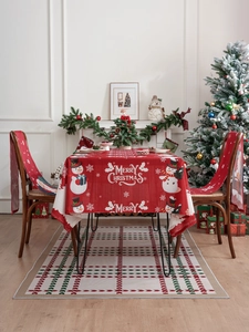 Detail of red Christmas tablecloth and chair covers with festive snowman and Merry Christmas print