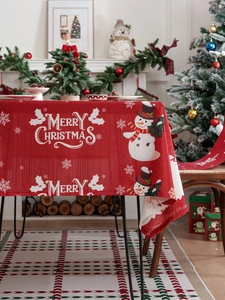 Detail of red Christmas tablecloth featuring snowman patterns and festive text texture