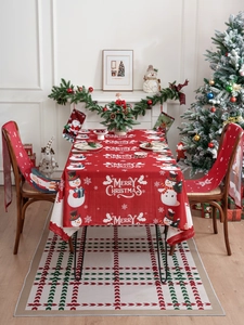 Detail of red Christmas tablecloth and chair covers featuring Santa and snowman patterns