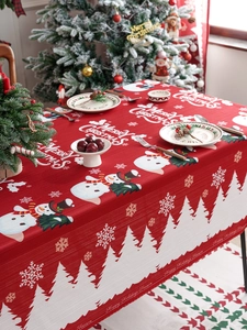 Detail of red Christmas tablecloth with snowman pattern and holiday typography texture
