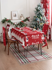 Detail of red Christmas tablecloth with snowman pattern and Merry Christmas text