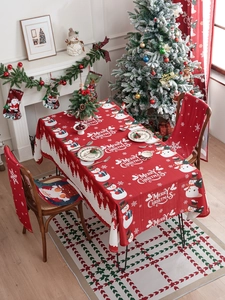 Detailed view of red Merry Christmas tablecloth and chair covers with festive patterns