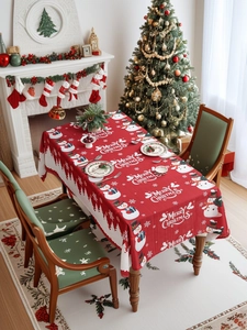 Close-up of red Christmas tablecloth featuring white snowmen and forest silhouette patterns