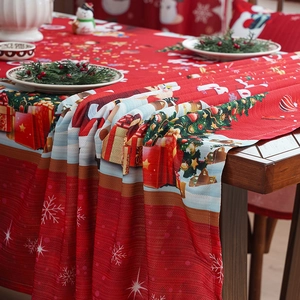 Festive red Christmas tablecloth with snowflake and holiday patterns on a wooden table