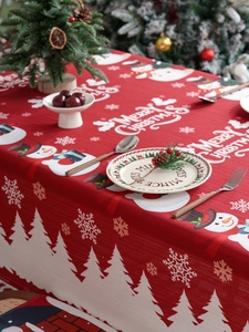 Detail view of red Christmas tablecloth with snowman patterns and fine fabric texture