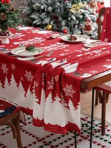 Detail view of red Christmas tablecloth with snowman pattern in festive dining setting