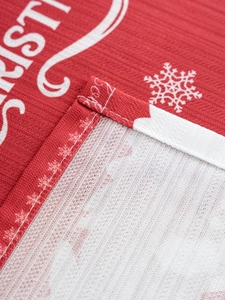 Detail of red Christmas tablecloth featuring white snowflakes and stitched edges