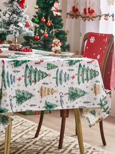 Detail of Christmas tablecloth featuring green tree patterns on white knit fabric texture