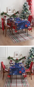 Detailed view of starry blue Christmas tablecloth with Santa Claus and red chair covers