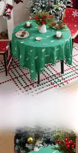 Detail of green Christmas tablecloth featuring reindeer embroidery and elegant tassel edges