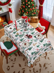 Detail of Christmas tablecloth with green trees and festive patterns in a cozy room set