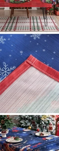 Detail of Christmas tablecloth with snowflake and Santa print plus red checkered edging