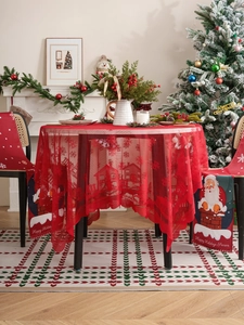 Detail of red Christmas lace tablecloth with snowflake patterns and Santa chair covers