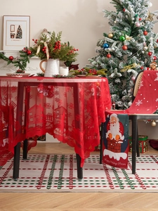 Close-up of red Christmas lace tablecloth with snowflake patterns and Santa chair covers
