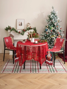Christmas dining set with red round tablecloth and Santa chair covers in a festive setting