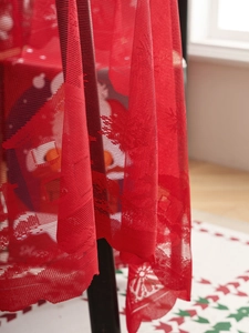 Detail view of red Christmas mesh fabric with white snowman and snowflake patterns