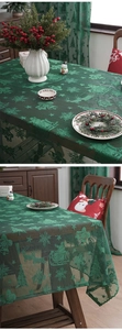 Detailed view of green Christmas lace tablecloth with reindeer and sleigh embroidery