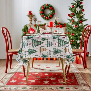 Christmas tablecloth with green tree patterns and festive decorations in a home setting