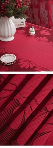 Macro detail of red festive lace tablecloth with intricate leaf jacquard texture and knitting