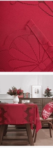 Macro detail of red knitted Christmas tablecloth with lace edges and bell patterns