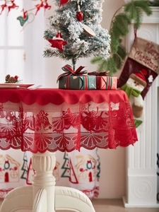 Detail van rood kant kersttafelkleed met patronen van rendieren en delicate sneeuwvlokken