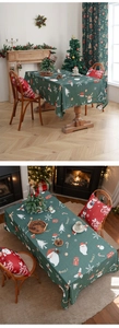 Detail of Christmas tablecloth with Santa, reindeer and snowflake prints in forest green