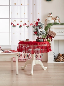 Detail van rood kant kersttafelkleed met geschulpte randen en bloemmotieven