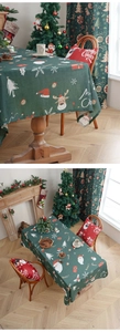 Detail of green Christmas tablecloth with Santa, reindeer patterns and festive holiday decor