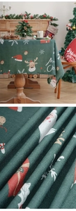 Close-up of dark green Christmas tablecloth fabric with reindeer and snowflake prints