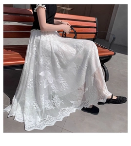 Detail of white lace skirt with embroidered butterfly patterns and scallop lace edge